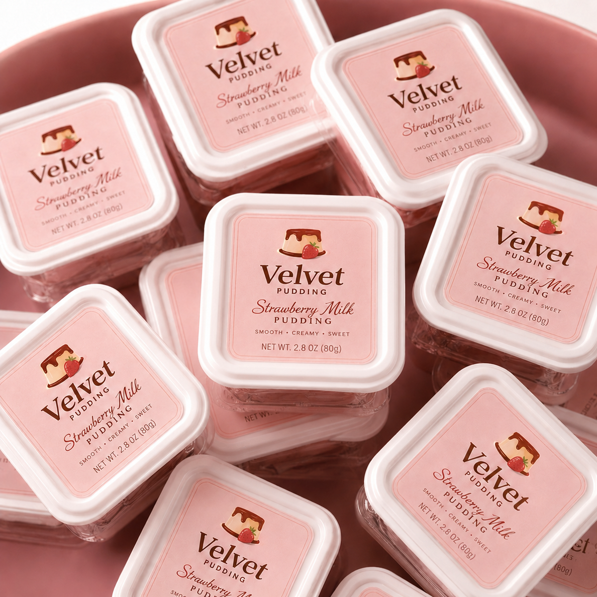 Custom rounded corner labels featuring a Velvet Pudding strawberry milk design applied on stacked dessert containers.