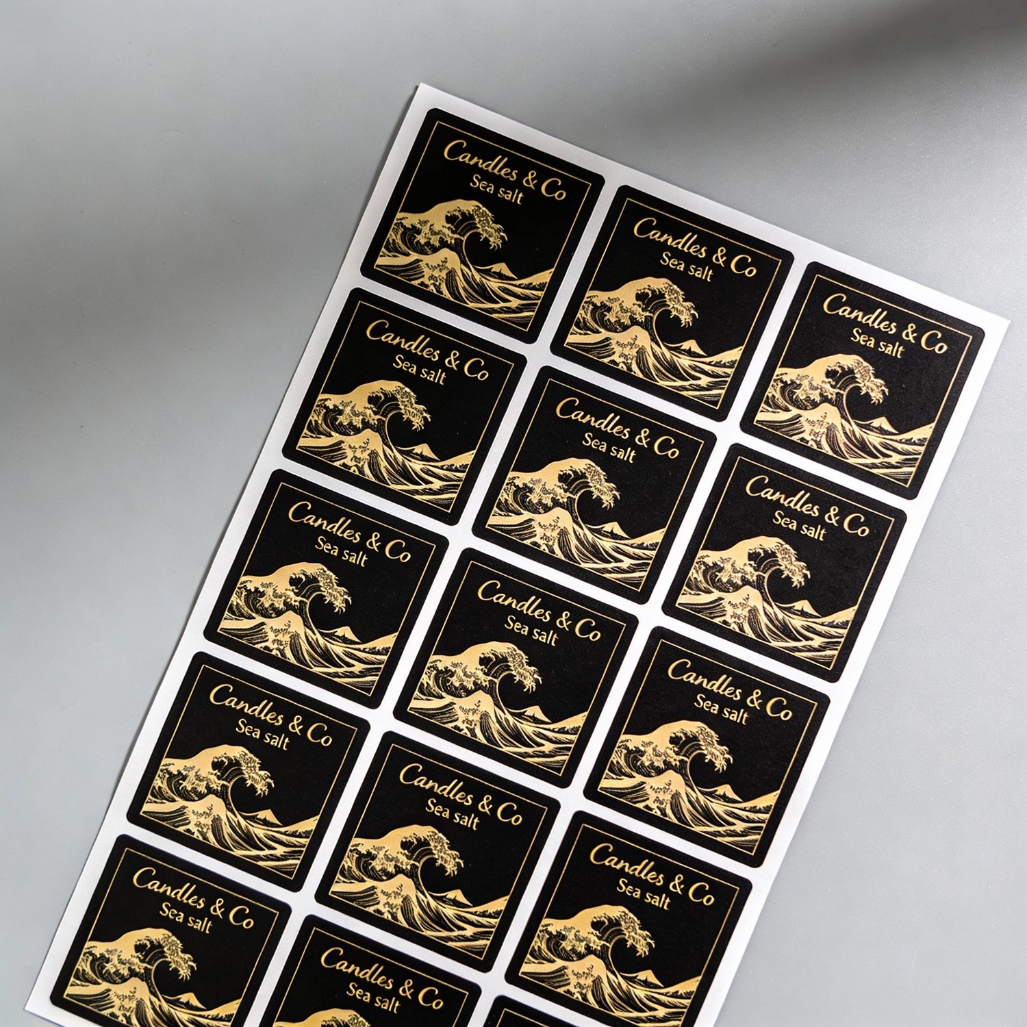 Sheet of black square stickers with gold Great Wave design, illustrating versatile square sticker labels ideal for inventory organization, pricing and small business product packaging.