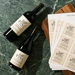 "Domaine du Gryphon" custom red wine labels with a classic gryphon emblem, shown as a stack of label sheets on a dark marble surface.