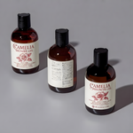 Waterproof custom cosmetic labels on camellia shower gel amber bottles, durable white vinyl for personal care