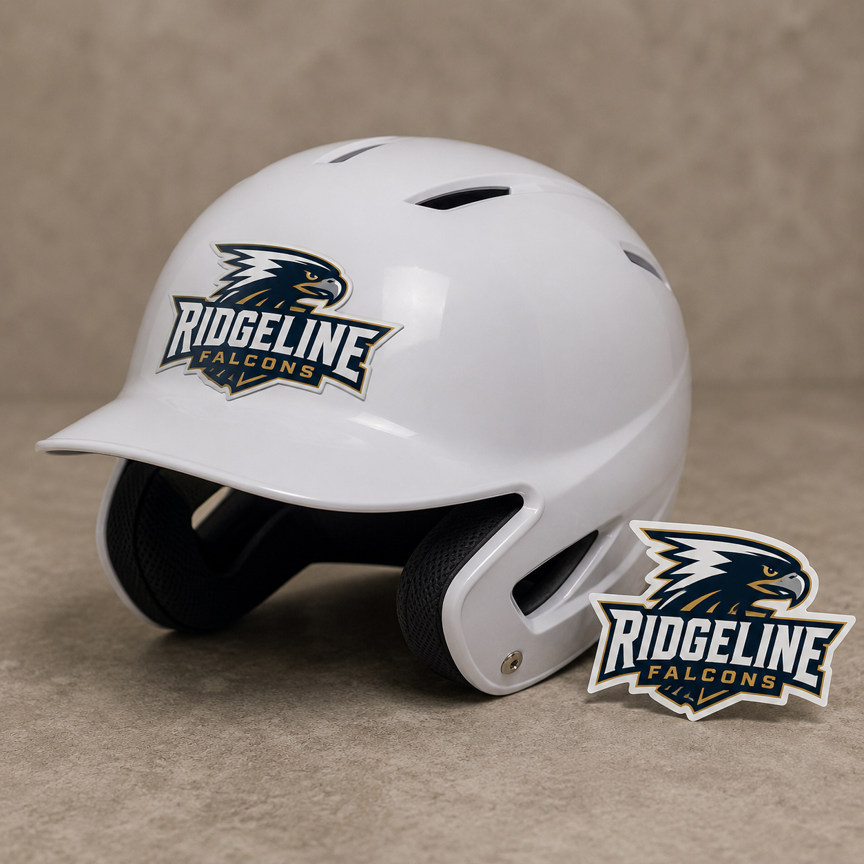Custom Ridgeline Falcons team logo sticker applied on a gloss white baseball batting helmet, with a matching die-cut vinyl decal placed next to it.