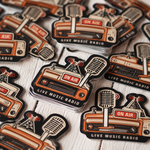 Bulk black and orange custom logo stickers arranged in stacked piles.